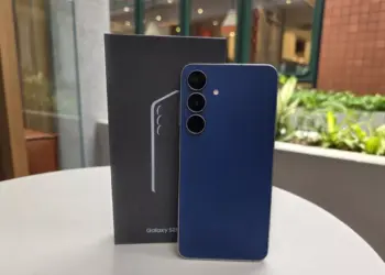 Unit Samsung Galaxy S26 FE warna biru tua berdiri di samping boks penjualan resminya.
