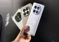Seseorang menggenggam tiga unit HP Redmi RAM 8 GB dengan bodi elegan dan kamera besar.