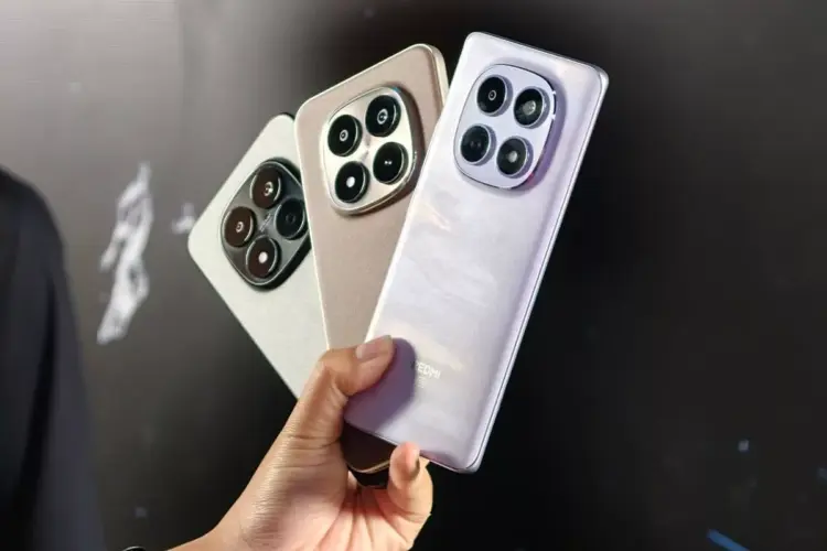 Seseorang menggenggam tiga unit HP Redmi RAM 8 GB dengan bodi elegan dan kamera besar.