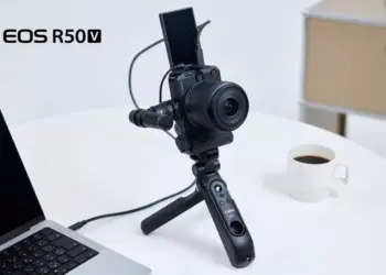 Kamera mirrorless Canon EOS R50 V terpasang pada tripod grip dengan layar terlipat ke atas untuk vlogging.
