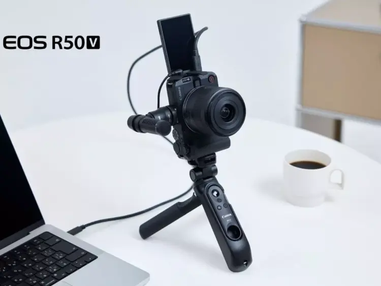 Kamera mirrorless Canon EOS R50 V terpasang pada tripod grip dengan layar terlipat ke atas untuk vlogging.
