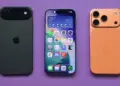 Tiga unit perangkat iPhone dengan varian warna hitam, layar depan aktif, dan warna orange tembaga di atas latar belakang ungu.