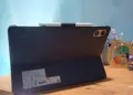 Tablet Xiaomi Terbaik merk Redmi warna hitam terpasang pada casing pendukung stylus di meja kerja