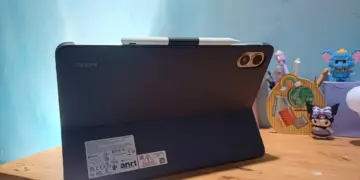 Tablet Xiaomi Terbaik merk Redmi warna hitam terpasang pada casing pendukung stylus di meja kerja