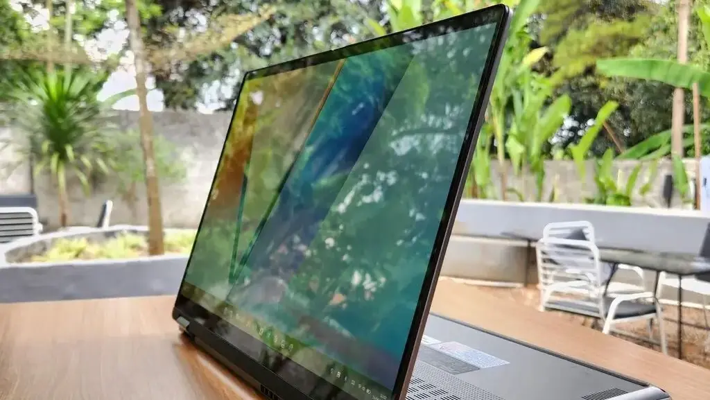 ASUS Vivobook 14 Flip posisi stand mode di atas meja kayu dengan layar sentuh lipat 360 derajat.