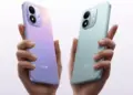 Dua tangan memegang smartphone Redmi Note 17 Pro warna ungu bermotif dan biru muda mengkilap dari tampak belakang.