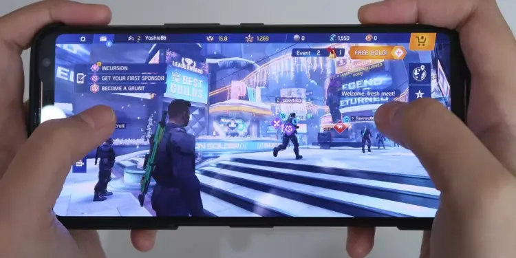 Seseorang sedang bermain game FPS di HP 1 jutaan dengan layar mulus 120Hz.