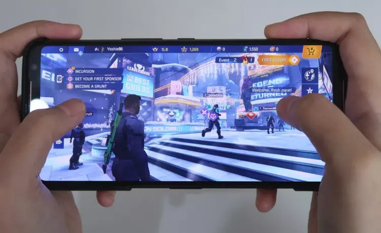 Seseorang sedang bermain game FPS di HP 1 jutaan dengan layar mulus 120Hz.