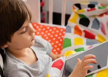 Anak-anak sedang santai menggunakan tablet murah 2026 untuk sekolah sambil berbaring belajar online
