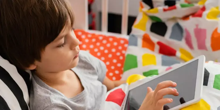 Anak-anak sedang santai menggunakan tablet murah 2026 untuk sekolah sambil berbaring belajar online