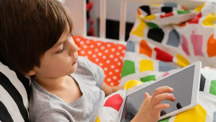 Anak-anak sedang santai menggunakan tablet murah 2026 untuk sekolah sambil berbaring belajar online