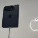 Penampakan bodi belakang iPhone Duo warna hitam terpasang pada stand pameran dengan logo Apple menyala di latar belakang.