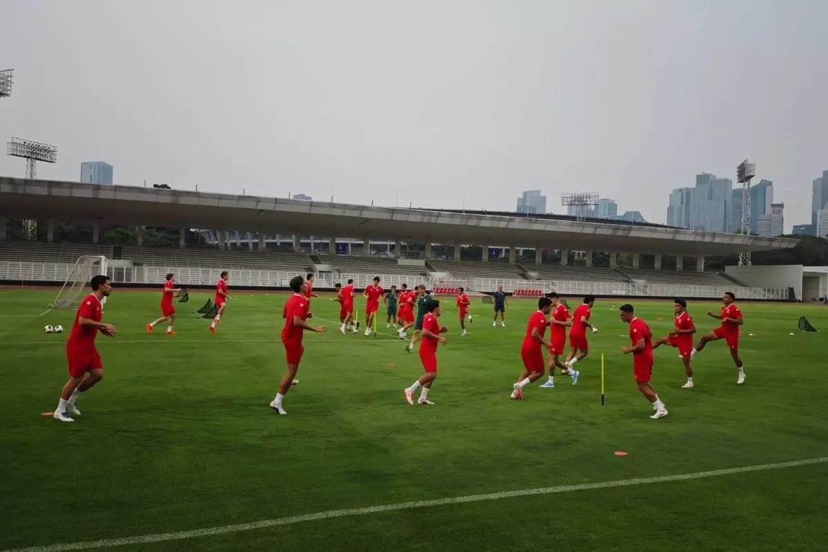 Timnas Indonesia sedang berlatih bersama di atas rumput hijau stadion.