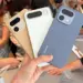 Seseorang memegang tiga unit HP Realme kamera 200MP dengan opsi warna emas, putih, dan biru di sebuah pameran gadget.