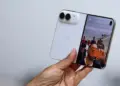 Seseorang memegang iPhone Duo kondisi terlipat menampilkan antarmuka kamera di layar luar.
