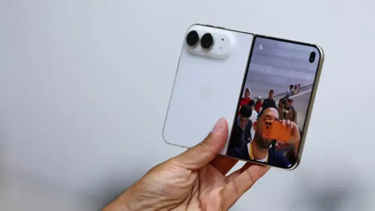 Seseorang memegang iPhone Duo kondisi terlipat menampilkan antarmuka kamera di layar luar.