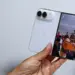 Seseorang memegang iPhone Duo kondisi terlipat menampilkan antarmuka kamera di layar luar.