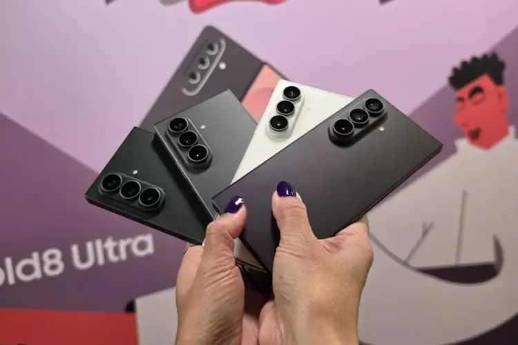 Seseorang memegang empat unit smartphone lipat Samsung Galaxy Z Fold dalam posisi mekar.