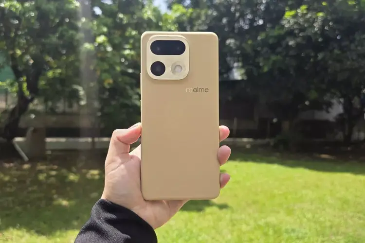 Bodi belakang HP kamera 200 MP realme warna krem bertekstur kulit dipegang tangan di luar ruangan