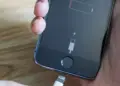 Layar iPhone boros baterai menunjukkan ikon baterai lemah dan meminta pengisian daya.