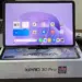 Tablet Infinix XPAD 30 Pro dengan layar menyala menampilkan antarmuka Android, diletakkan di atas kotak kemasan resminya.