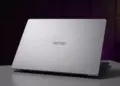Tampilan cover belakang laptop TECNO berwarna silver minimalis di atas meja.