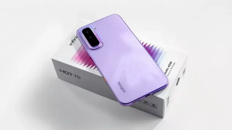 Smartphone Infinix Hot 70 warna ungu diletakkan di atas kotak kemasan produk.