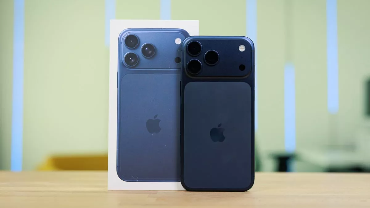 Unit iPhone 17 Pro warna biru gelap berdiri bersisian dengan kotak kemasan resminya.