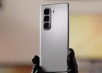 Tampilan bodi belakang HP Infinix murah warna perak dengan tiga kamera vertikal yang dipegang tangan.