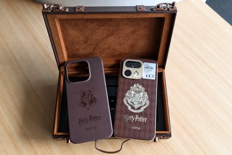 Casing dan bodi belakang Realme 16 Pro Edisi Harry Potter dengan logo Hogwarts di dalam kotak koper klasik.