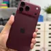 Seseorang menggenggam iPhone 18 Pro warna merah marun dengan desain modul kamera baru yang mendukung fitur anti foto AI.