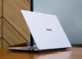 Tampilan bodi belakang ASUS Vivobook S14 S5452MA berbahan metal tipis dan elegan di atas meja kayu.