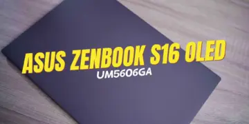 Tampilan cover laptop ASUS Zenbook S16 OLED UM5606GA varian Antrum Grey berbahan Ceraluminum di atas meja kayu.