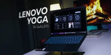 Laptop Lenovo Yoga Slim 7a 14AGP11 berwarna gelap diletakkan di atas stand laptop meja kerja studio.