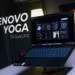 Laptop Lenovo Yoga Slim 7a 14AGP11 berwarna gelap diletakkan di atas stand laptop meja kerja studio.