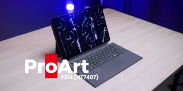 Laptop hibrida detachable ASUS ProArt PZ14 berwarna abu-abu tua di atas meja kayu dengan pencahayaan studio biru cobalt.