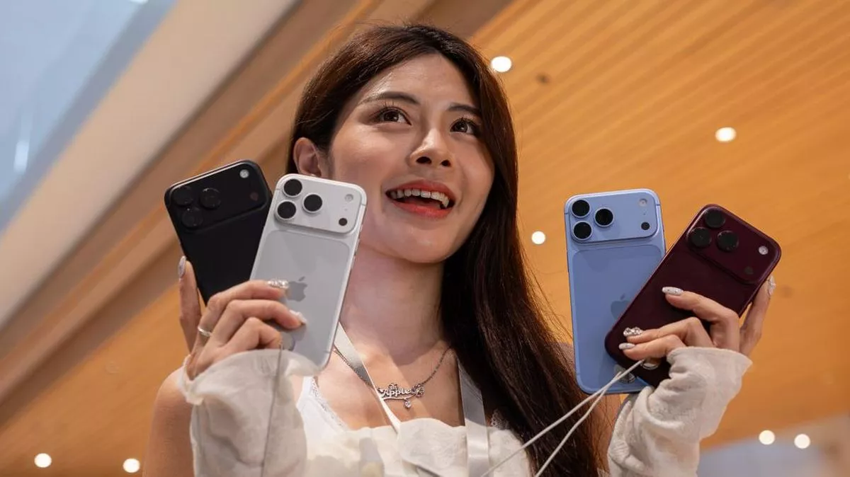 Seorang wanita memegang empat varian warna iPhone 18 Pro di gerai penjualan resmi.