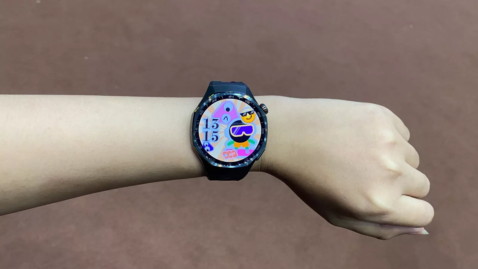 Penggunaan smartwatch Huawei Watch GT 7 Series warna hitam di pergelangan tangan dengan tampilan watch face kartun menarik.