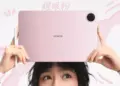 Seseorang memegang Honor Win Pad warna pink beserta pena stylus di atas kepala.