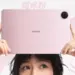 Seseorang memegang Honor Win Pad warna pink beserta pena stylus di atas kepala.