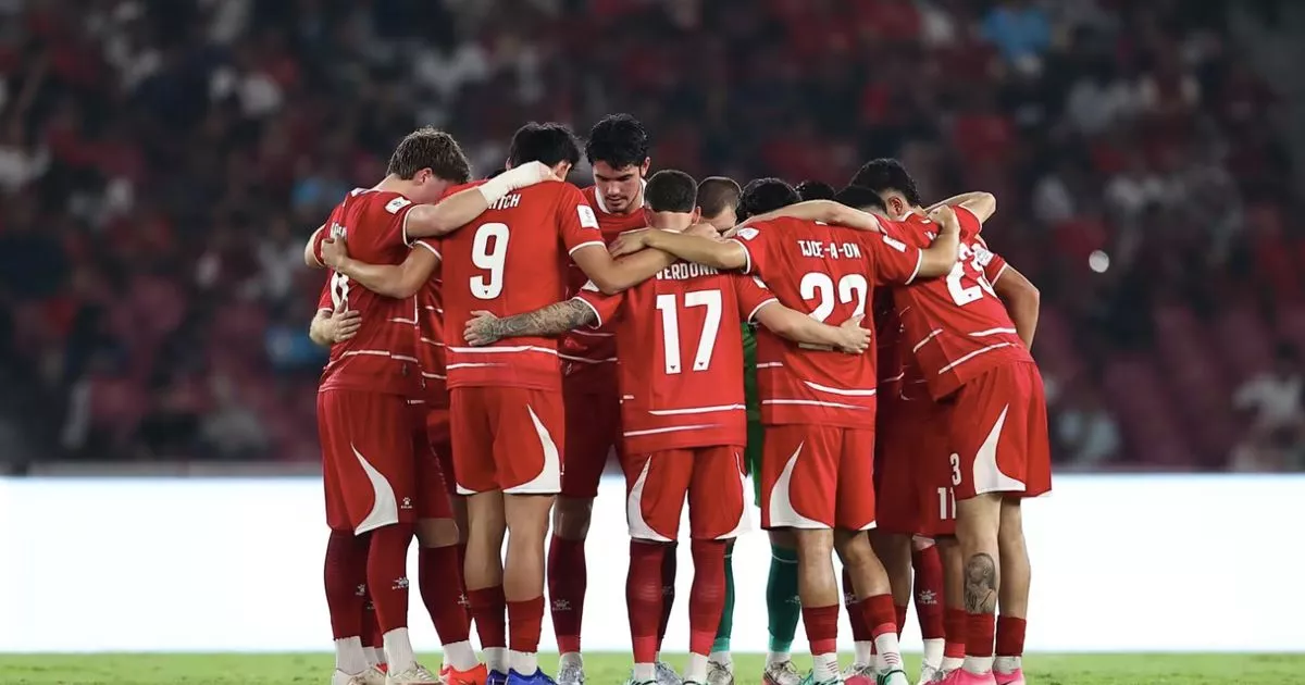 Para pemain Timnas Indonesia berpelukan dalam lingkaran di tengah lapangan sebelum pertandingan dimulai.