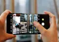 Penggunaan mode Pro pada kamera smartphone untuk mengatur fokus dan pencahayaan foto suasana jalanan kota.