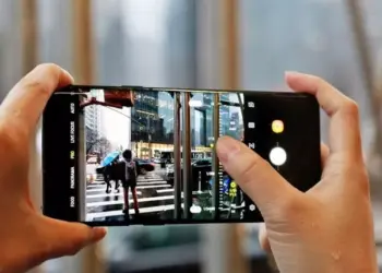 Penggunaan mode Pro pada kamera smartphone untuk mengatur fokus dan pencahayaan foto suasana jalanan kota.