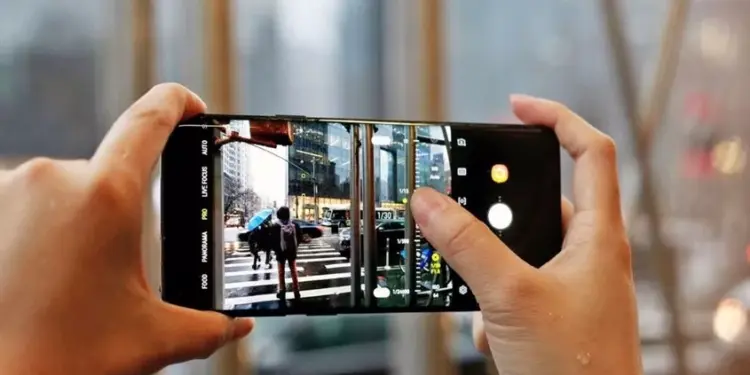 Penggunaan mode Pro pada kamera smartphone untuk mengatur fokus dan pencahayaan foto suasana jalanan kota.