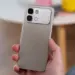 Tangan memegang bodi belakang HP Infinix warna silver dengan modul kamera 50MP.