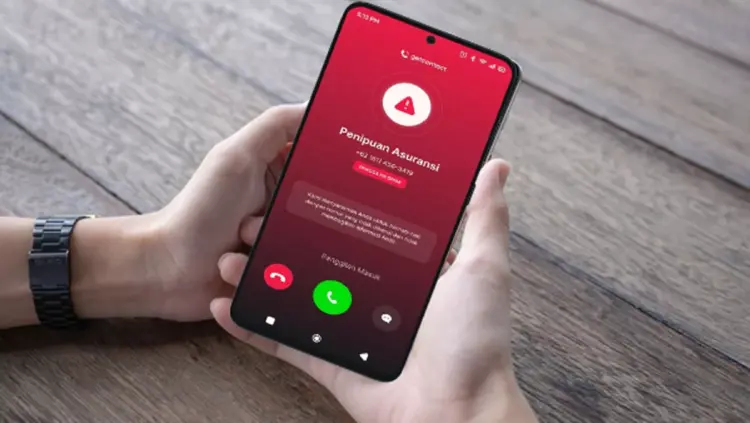 Layar smartphone menampilkan panggilan masuk dari nomor HP tak dikenal yang terdeteksi sebagai spam atau penipuan.
