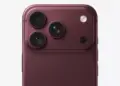 Close up modul kamera belakang tiga lensa pada konsep bodi merah maroon dalam isu penyesuaian produksi iPhone 18 Pro.