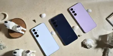 Tiga unit HP Samsung 5 Jutaan dalam varian warna putih, hitam, dan ungu diletakkan di atas meja