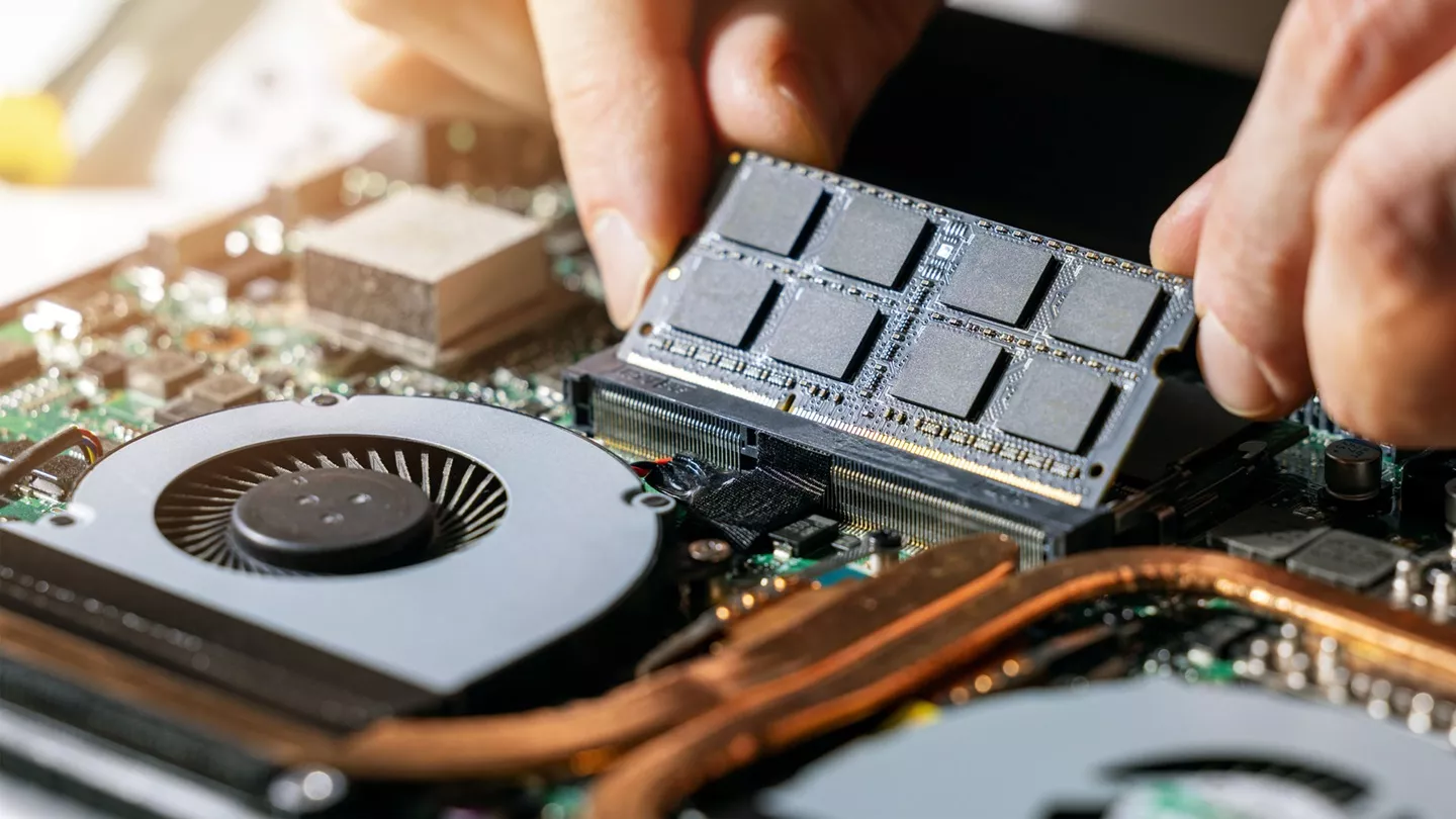 Pemasangan kepingan modul RAM SO-DIMM pada motherboard laptop untuk mengatasi masalah RAM laptop penuh.