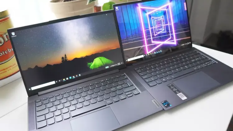 Perbandingan dua laptop Lenovo Yoga Pro 7i dan IdeaPad Slim di atas meja kerja